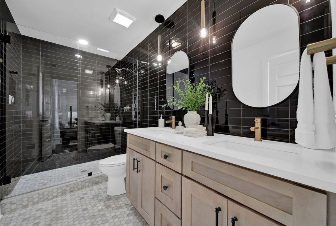 Bathroom with an S2 Honey wood vanity, black tile shower and round mirror