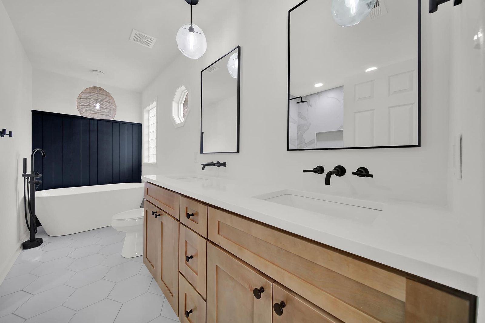 Bathroom with an S2 Honey wood vanity, navy tile shower and black fixtures
