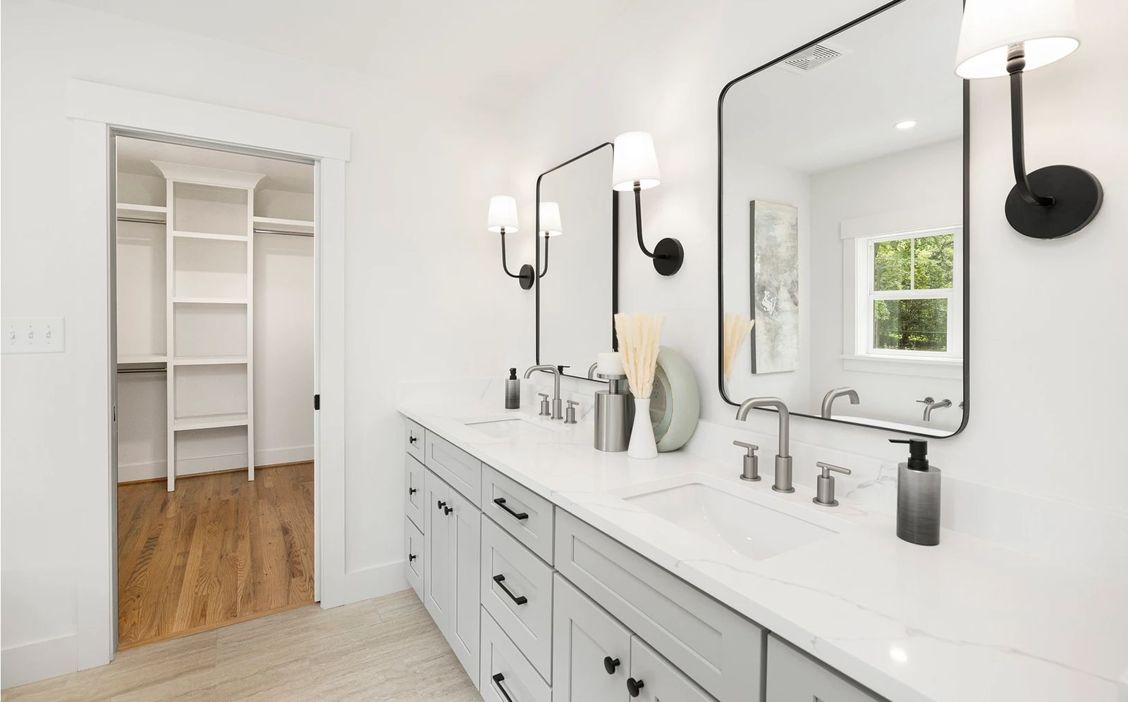 Bathroom with a white shaker double vanity, black-framed mirrors and walk-in closet