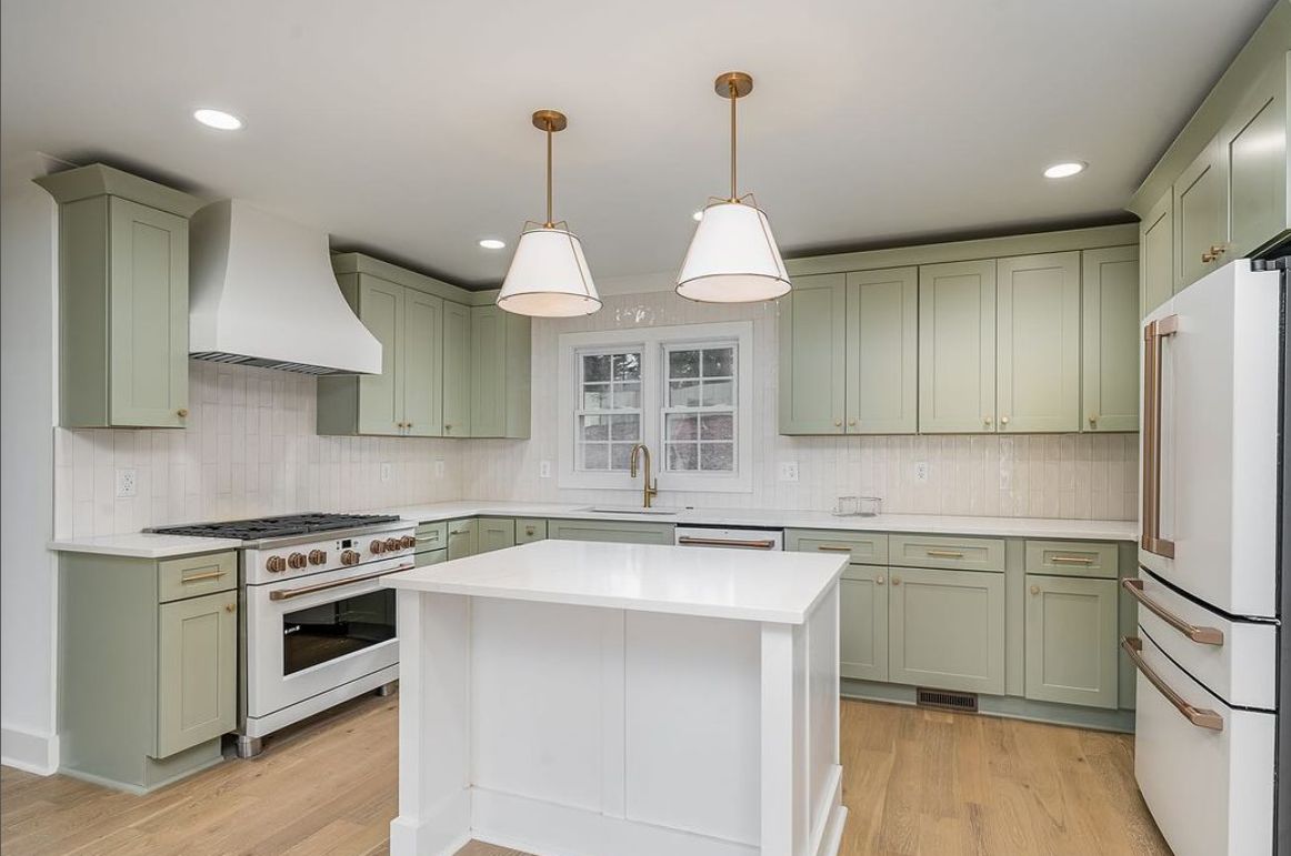 Kitchen with D3 Shallow Green shaker cabinets, white island and white pendants
