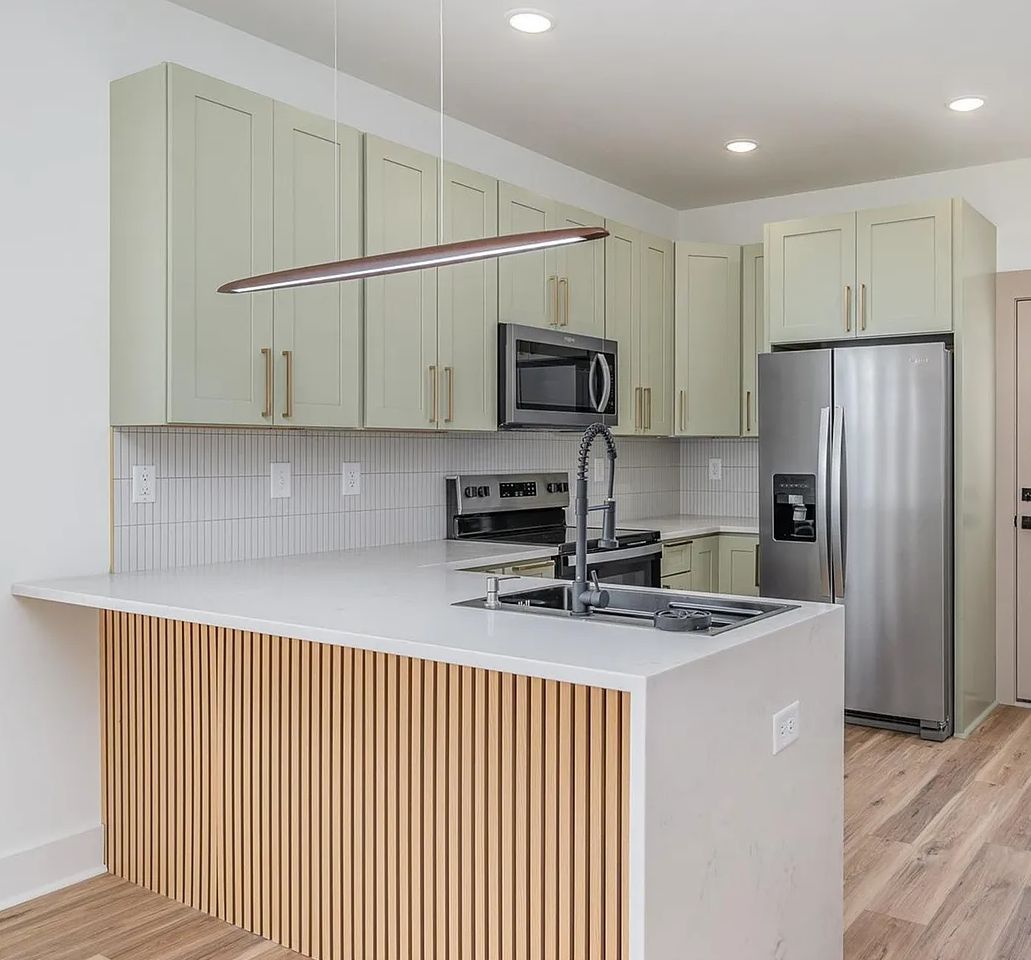 Kitchen with D3 Shallow Green shaker cabinets and a wood slat island