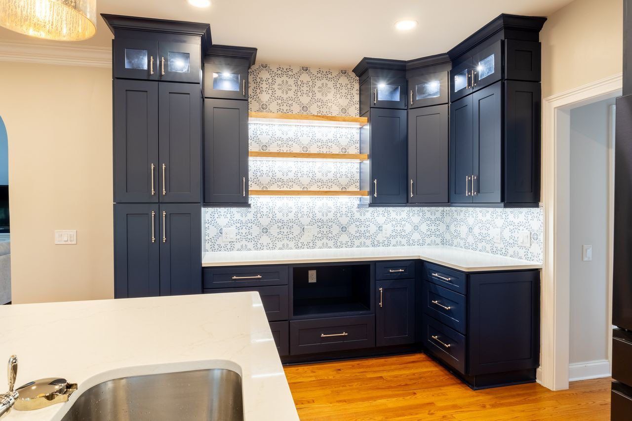 Kitchen with D4 Navy shaker cabinets, patterned tile backsplash and floating shelf
