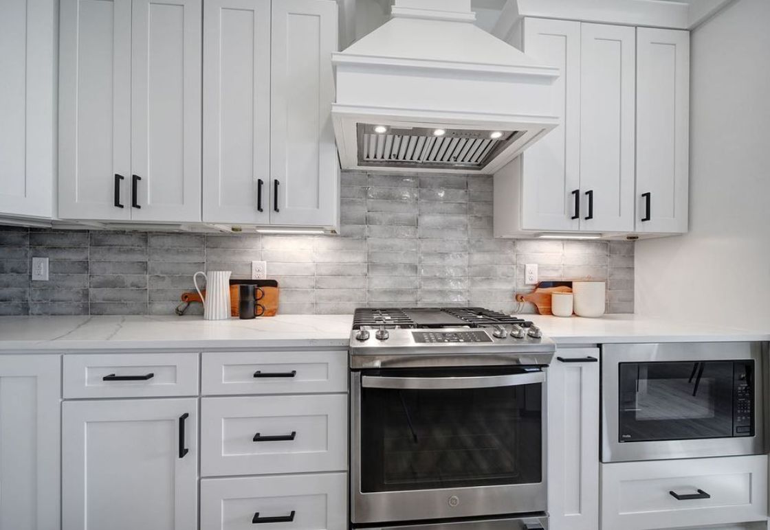 Kitchen with D6 Dove Grey shaker cabinets, grey subway tile and white range hood