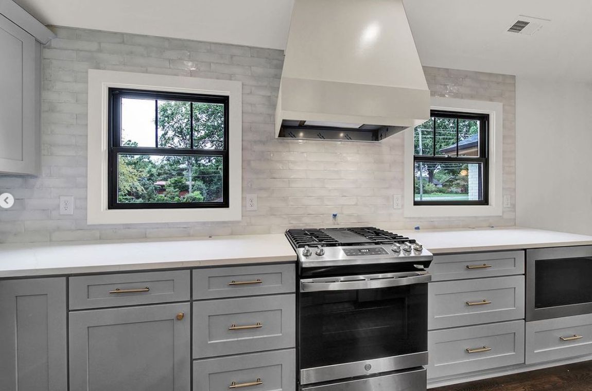 Kitchen with D6 Dove Grey shaker cabinets, white range hood and stainless range
