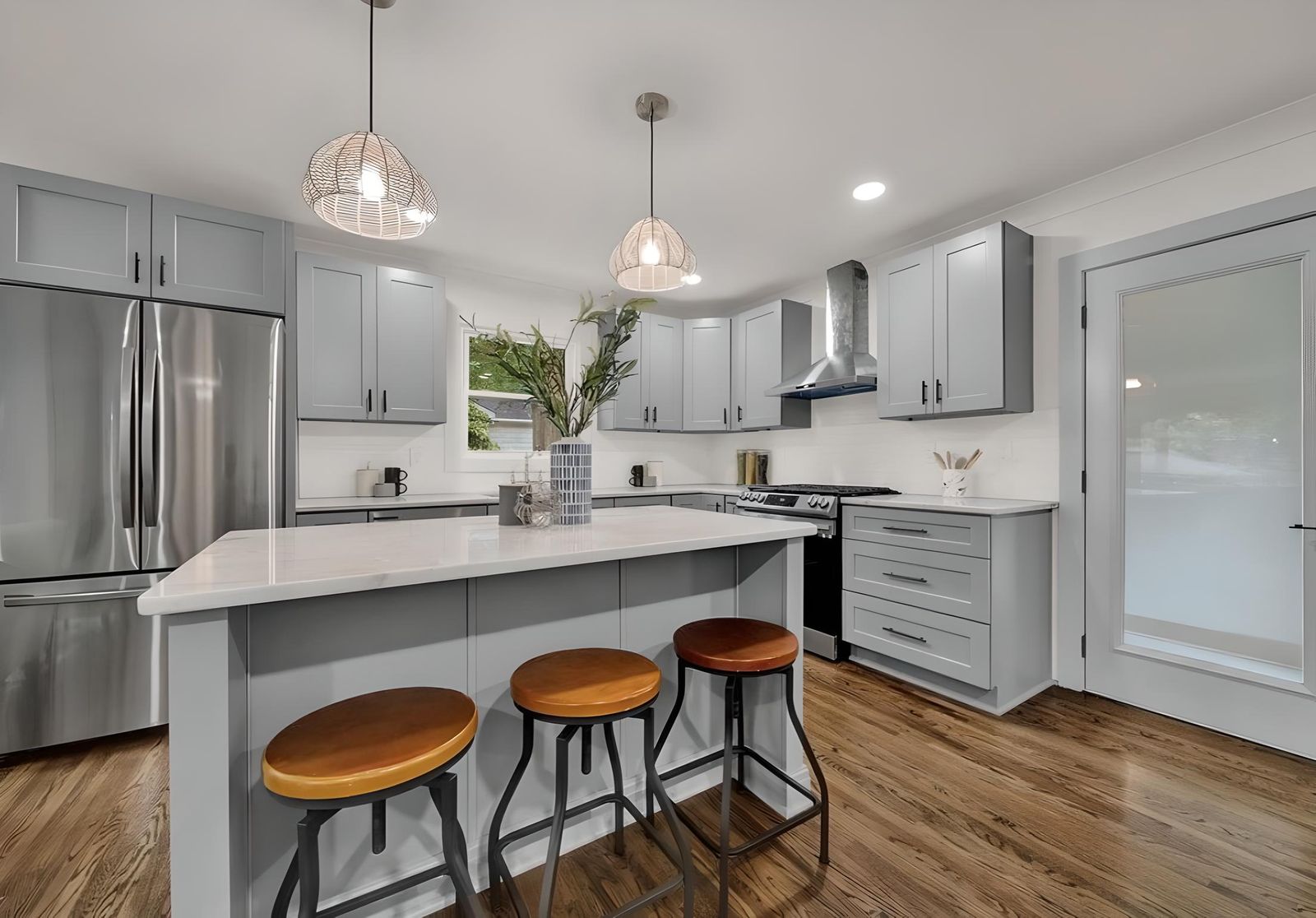 Kitchen with D6 Dove Grey shaker cabinets, white island and stainless appliances