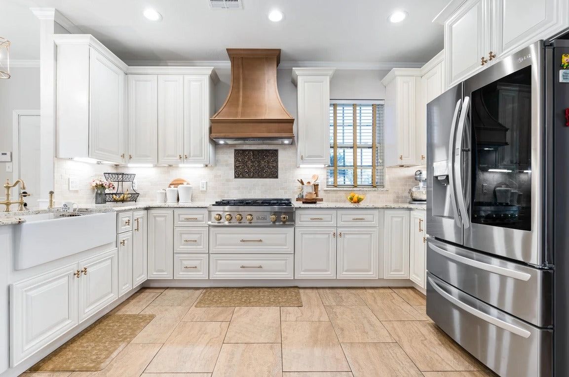 Kitchen with D9 Pearl White shaker cabinets, copper range hood and stainless refrigerator
