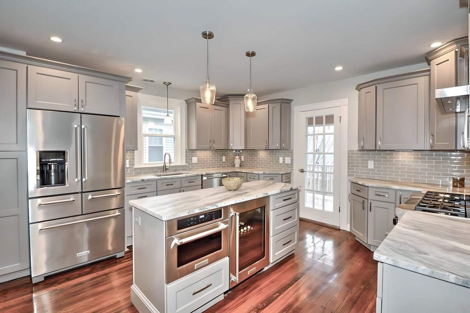 Kitchen with G4 Grey shaker cabinets, stainless appliances and glass pendants