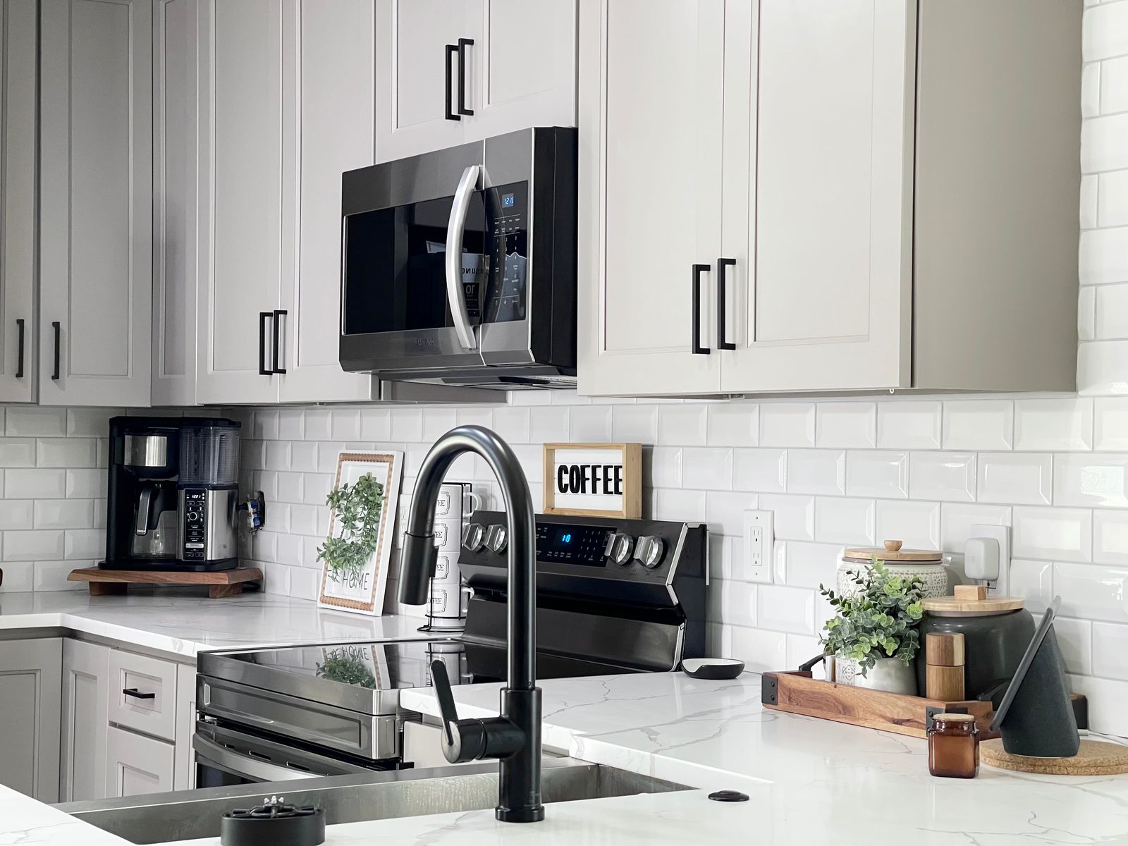 Kitchen with G4 Grey shaker cabinets, white subway tile and black faucet