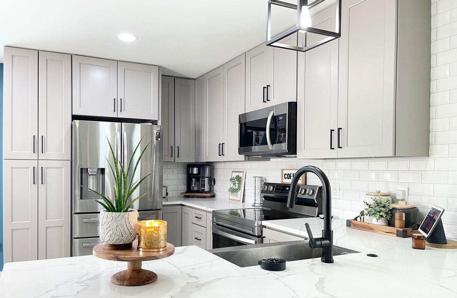 Kitchen with G4 Grey shaker cabinets, white subway tile and black faucet
