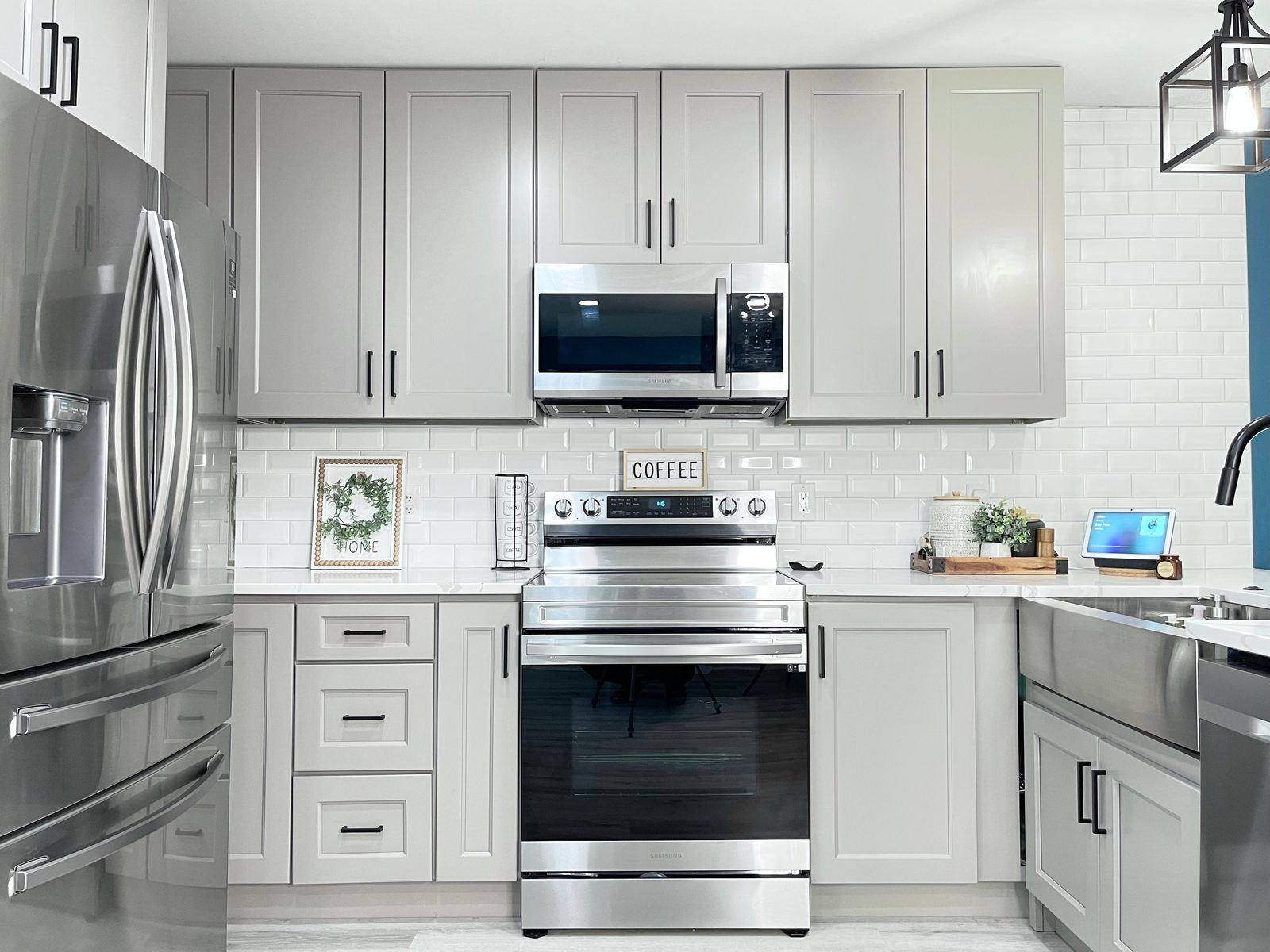 Kitchen with G4 Grey shaker cabinets, white tile backsplash and stainless range