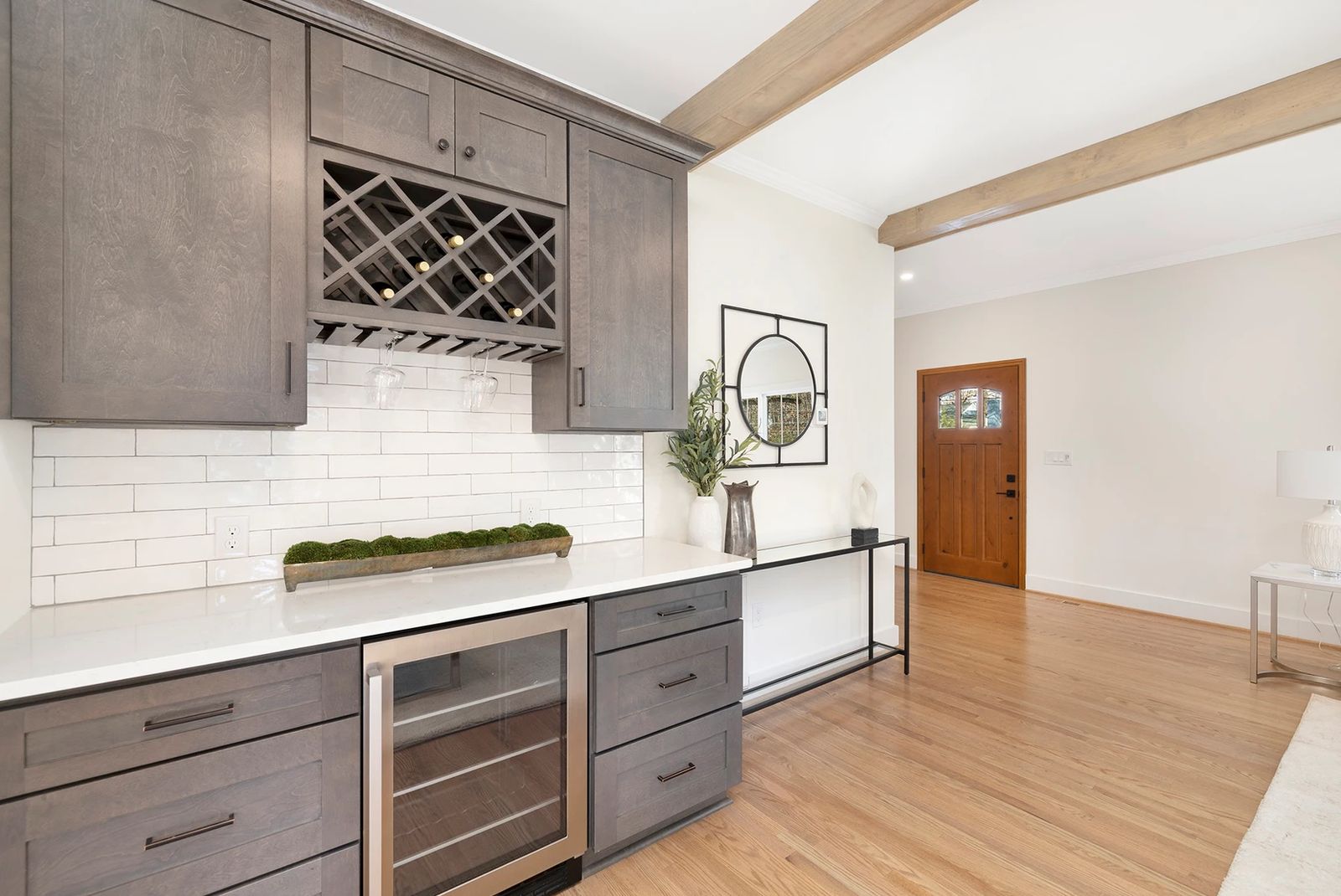 Kitchen with grey shaker cabinets, wine rack and glass-front beverage center