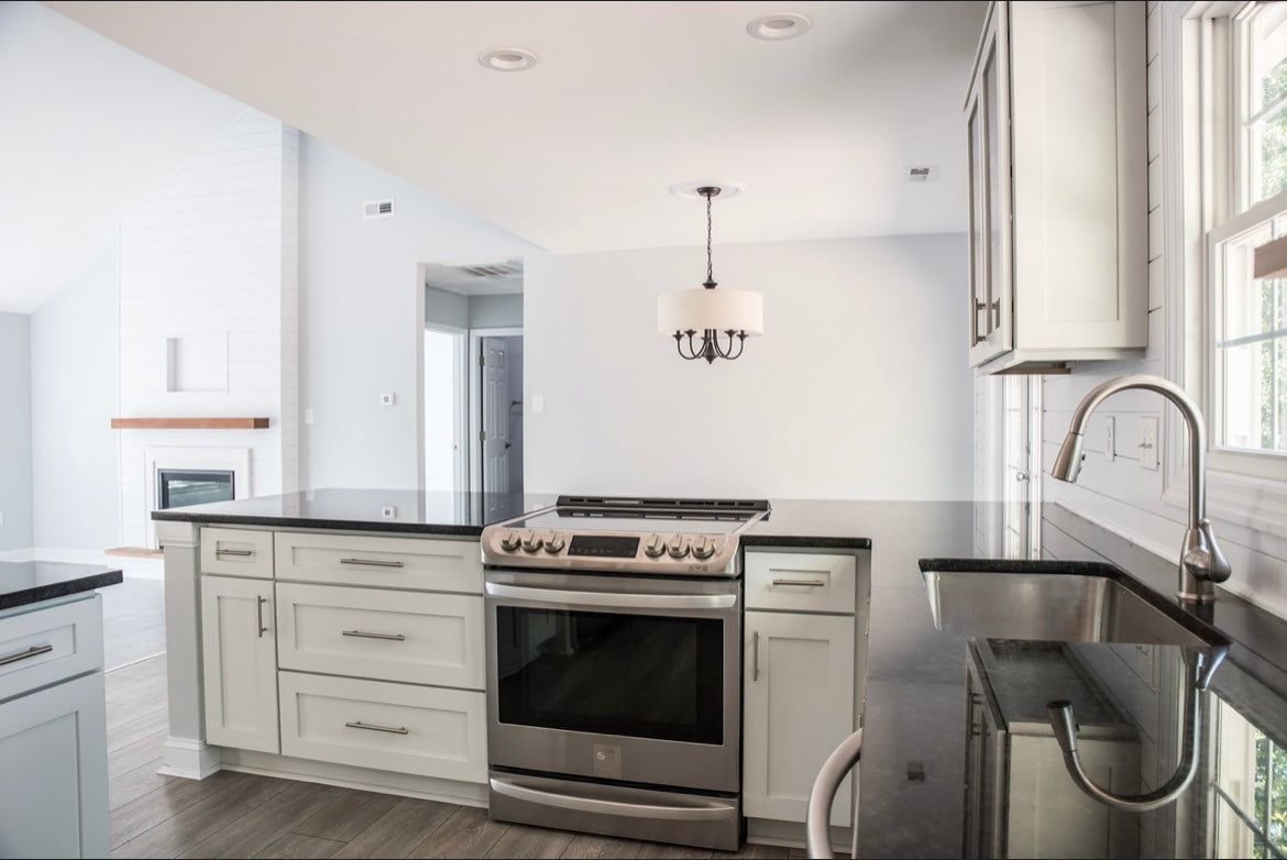Kitchen with L2 Aveley white shaker cabinets, stainless range and quartz counters