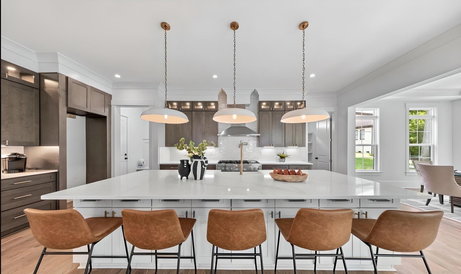 Kitchen with S1 Ash Grey wood-grain cabinets, long white island and leather stools