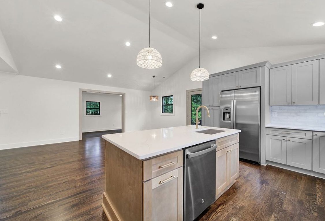 Kitchen with S2 Honey light wood cabinets, white island and stainless appliances