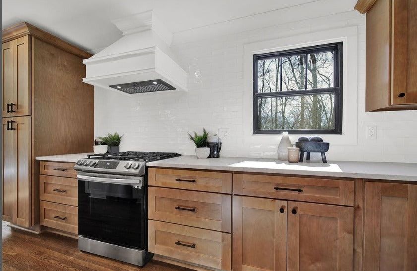 Kitchen with S2 Honey wood shaker cabinets, white range hood and black window