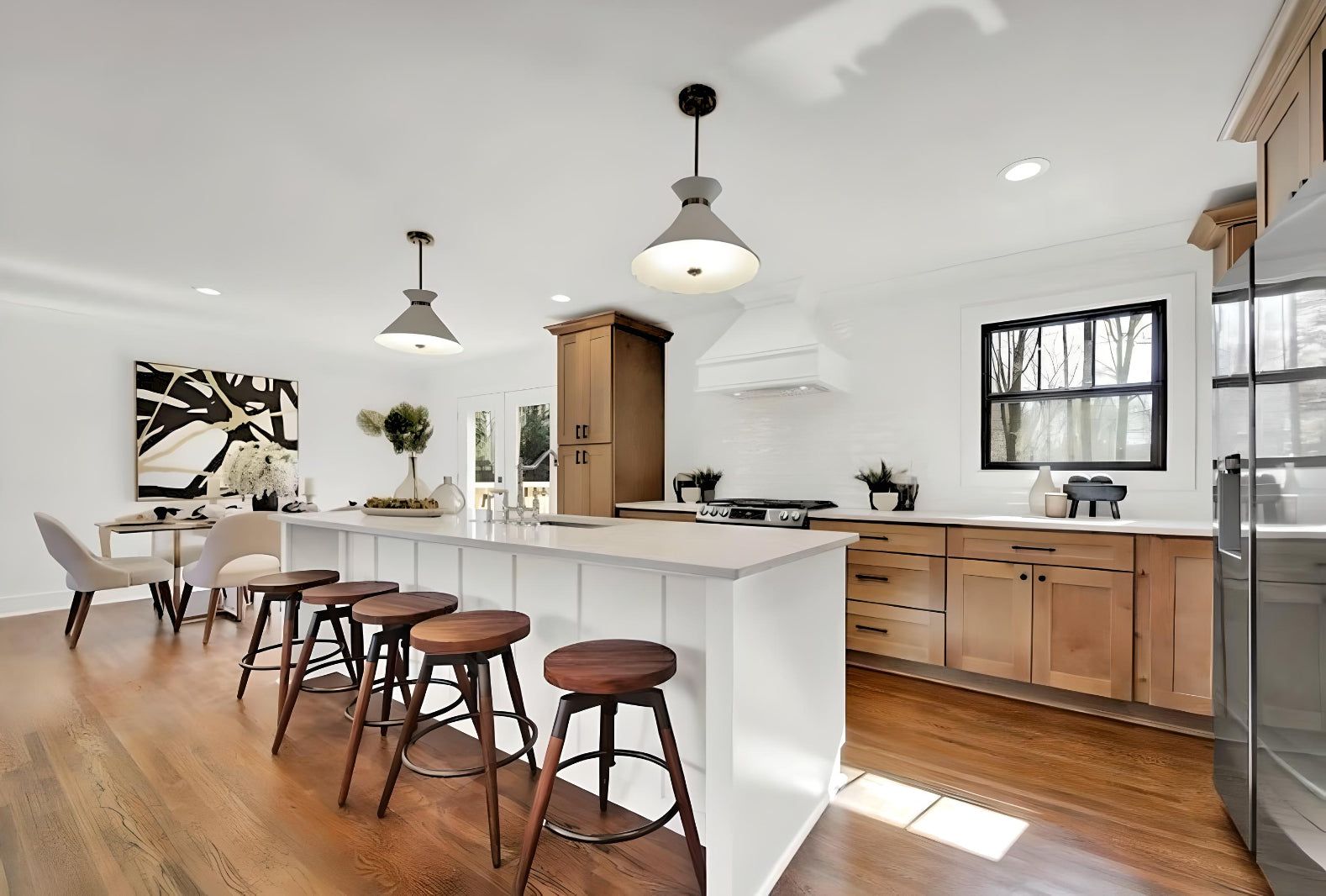 Kitchen with white uppers and S2 Honey wood island, wood stools and glass pendants