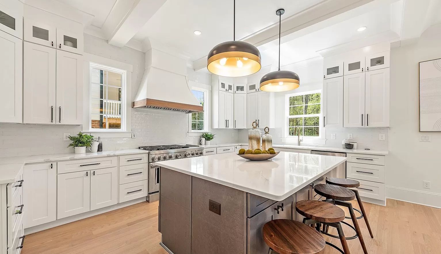 White shaker kitchen with an S1 Ash Grey island, white range hood and brass pendants