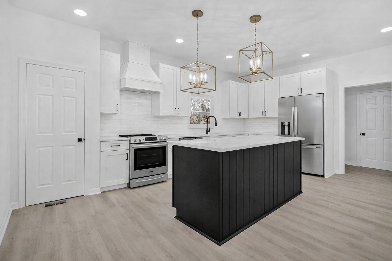 White shaker kitchen with a D8 Black Swan island and gold cage pendants