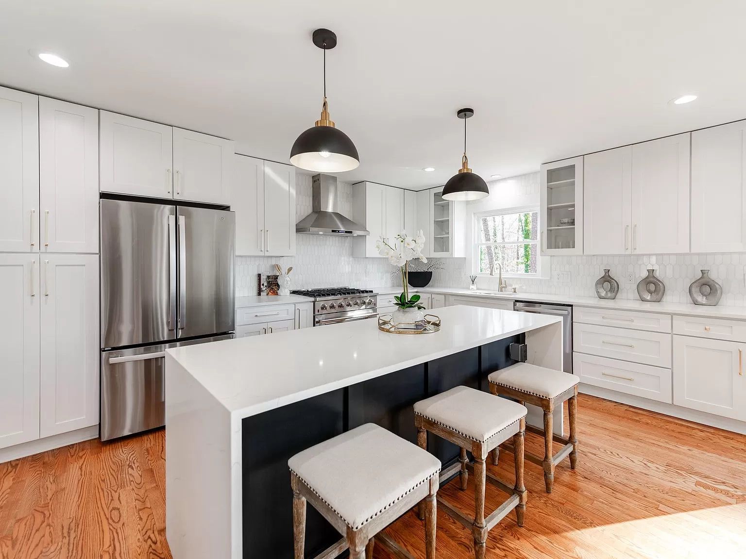 White shaker kitchen with a D8 Black Swan waterfall island and black pendants