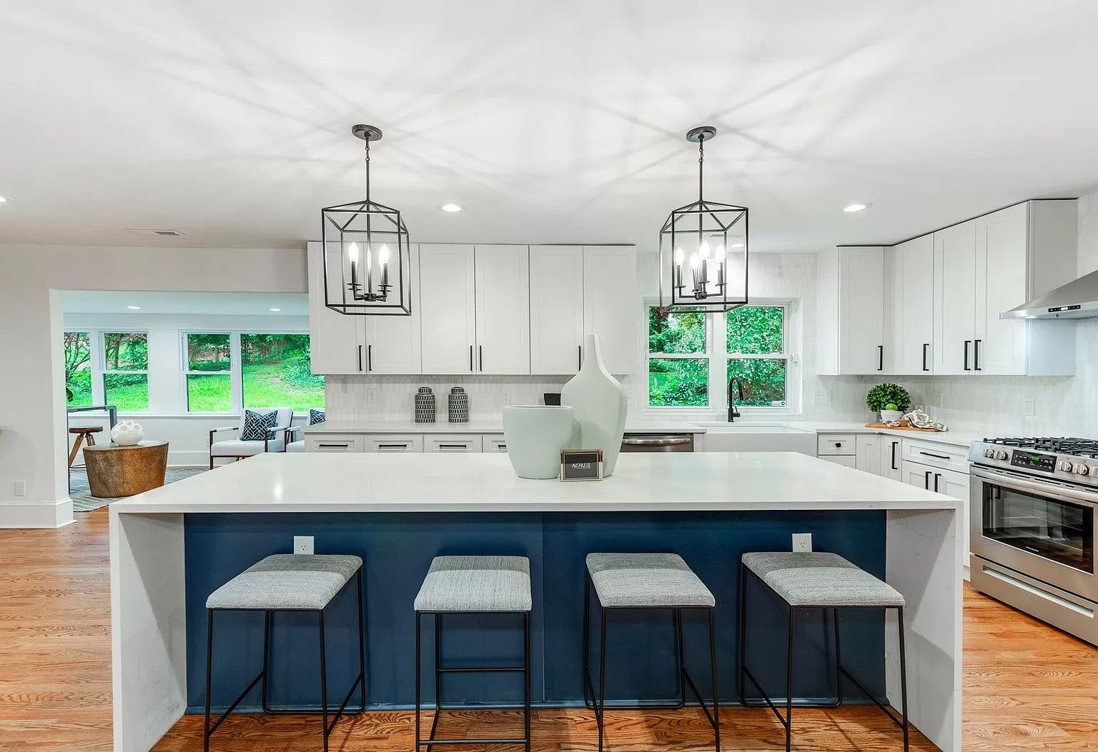 White shaker kitchen with a G8 navy island, upholstered stools and lantern pendants