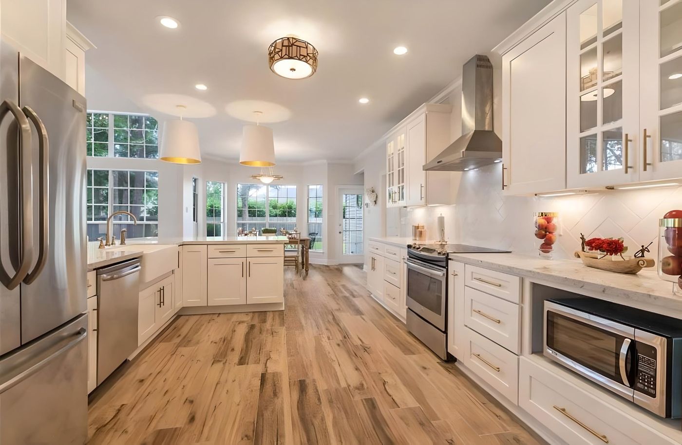 White shaker kitchen with glass uppers, stainless range hood and hardwood floors