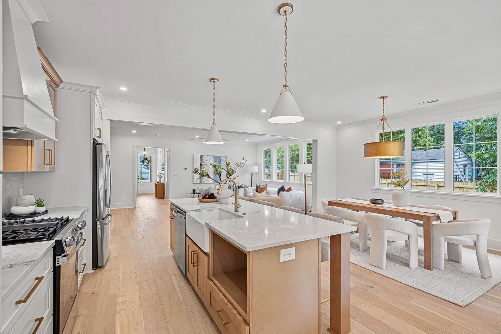 White shaker kitchen with natural oak island opening to a dining area