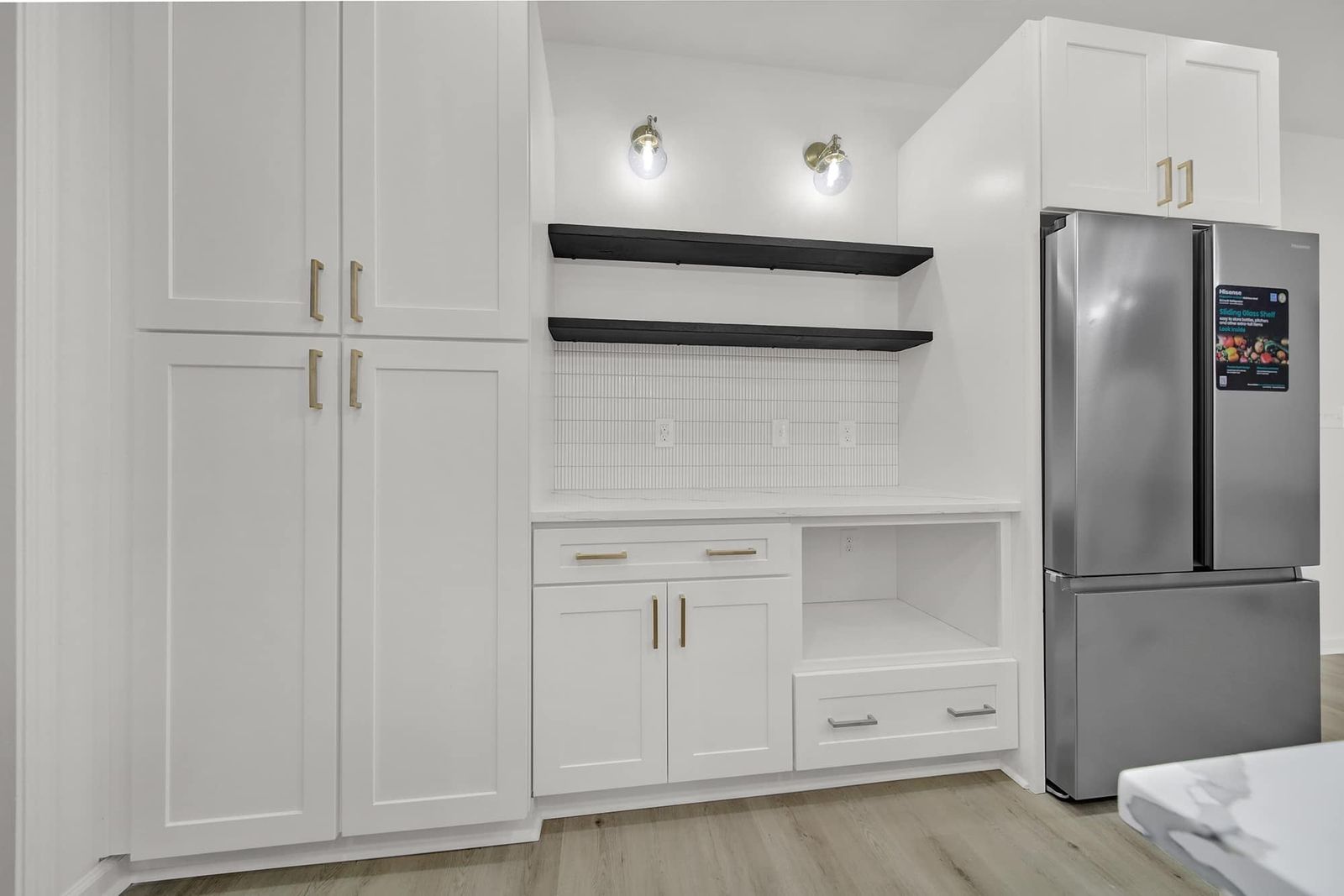 White shaker pantry cabinets with D8 Black Swan floating shelves beside a stainless refrigerator